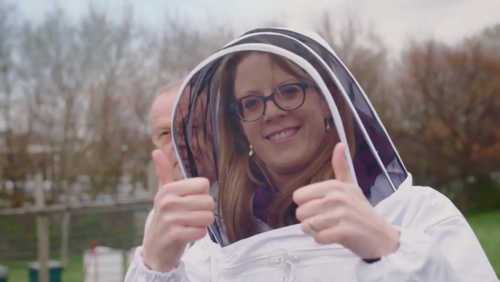 Sally Williams in a beekeeper's veil giving a thumbs up during filming